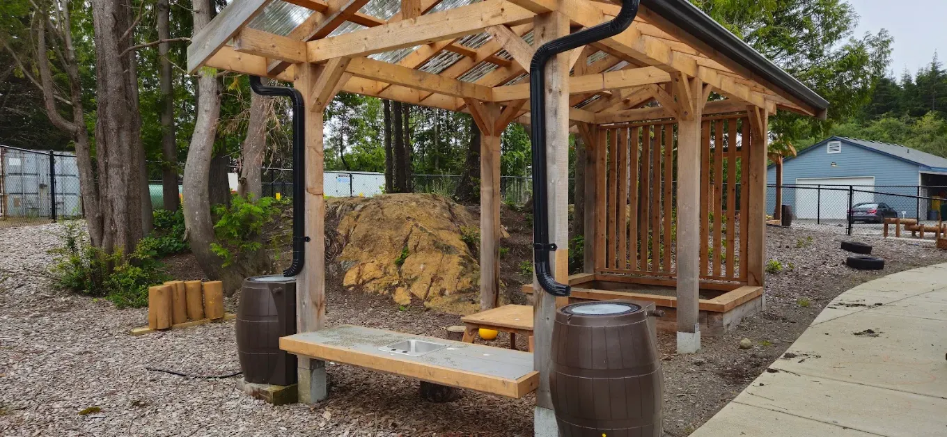 Close-up of the outdoor mud kitchen sink and rain barrels at Comfort First Early Learning
